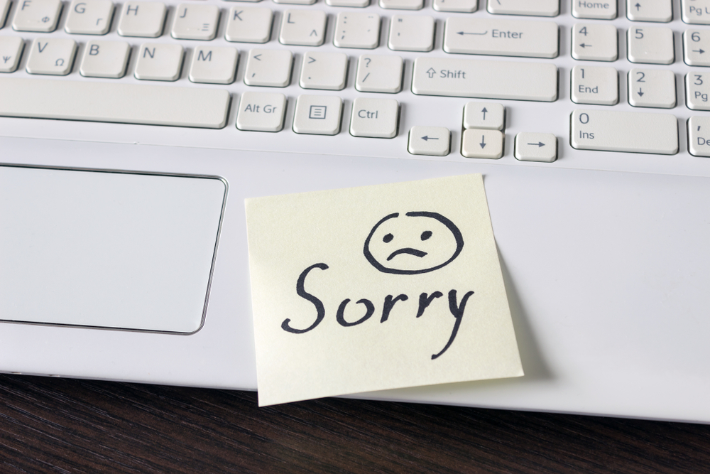 A laptop with a post-it note saying sorry